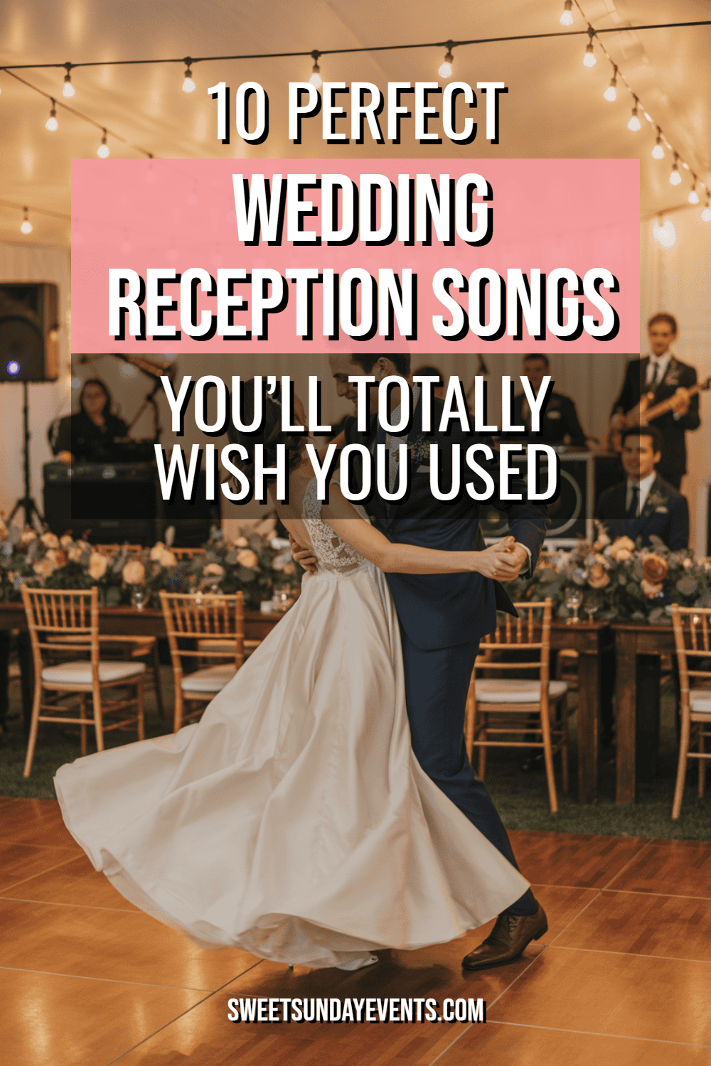 Couple dancing joyfully at a romantic wedding reception with elegant decor and live music.