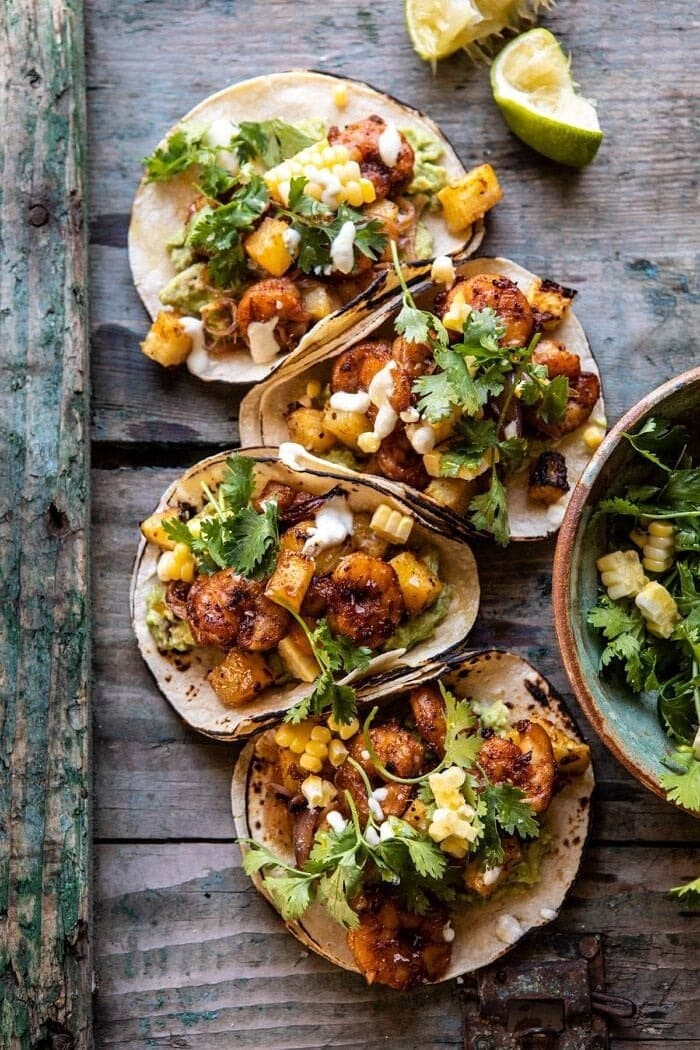 Sheet pan hawaiian pineapple shrimp tacos on top of wooden table.