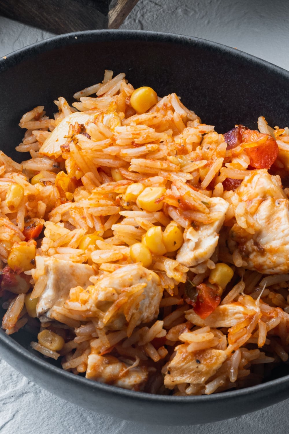 Rice mixed in skillet with  green peppers and onions, chicken, rice, salsa, and shredded cheese.