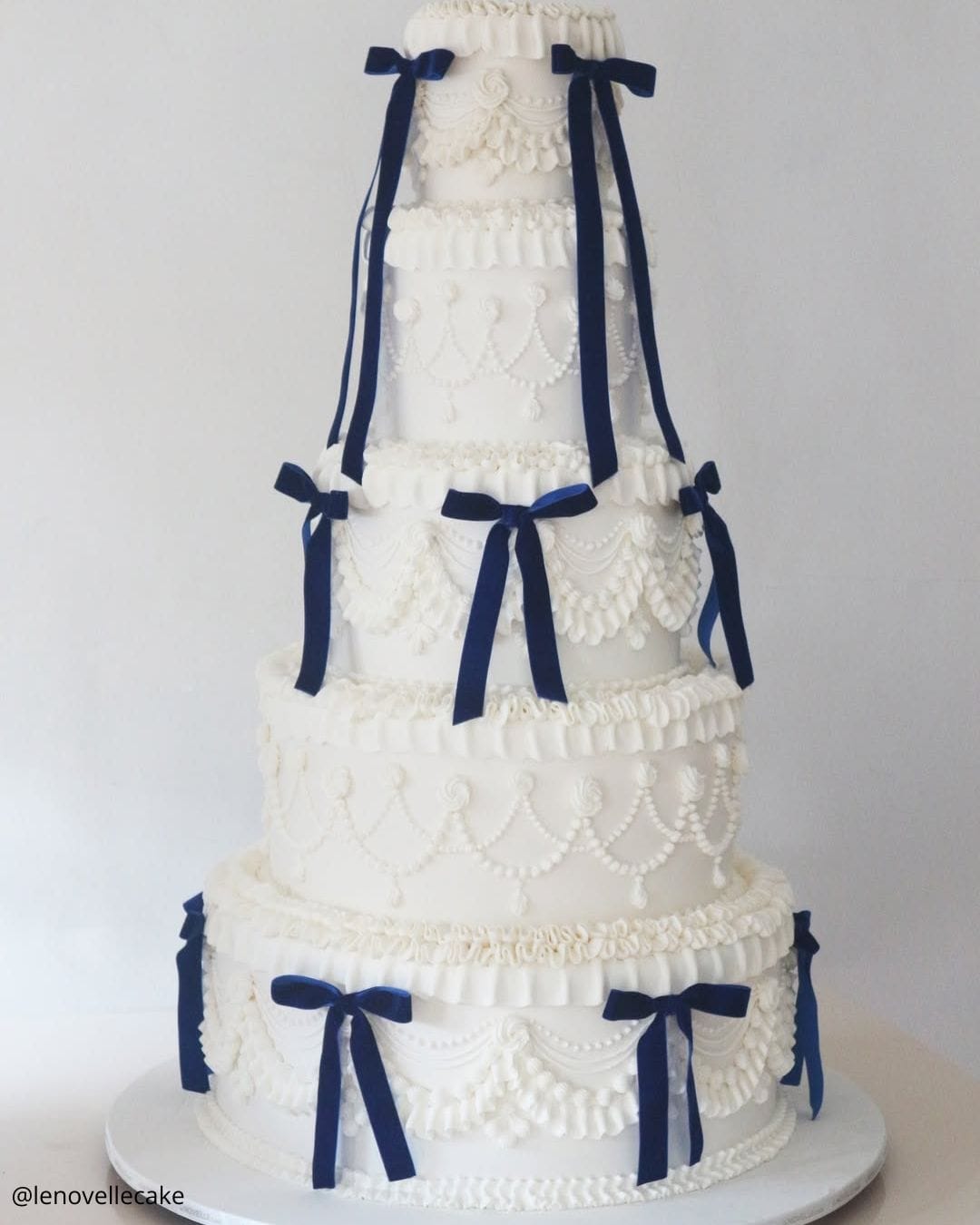 unique wedding cakes tall five tiered white vintage piped cake with navy blue bows lenovellecake
