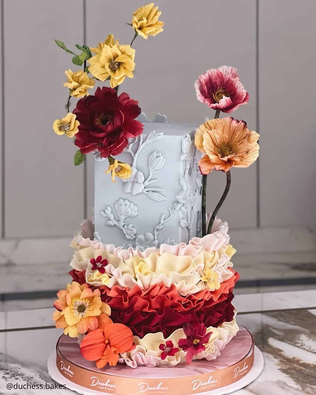 unique wedding cakes artistic tall grey cake with vibrant ruffles and flowers duchess bakes