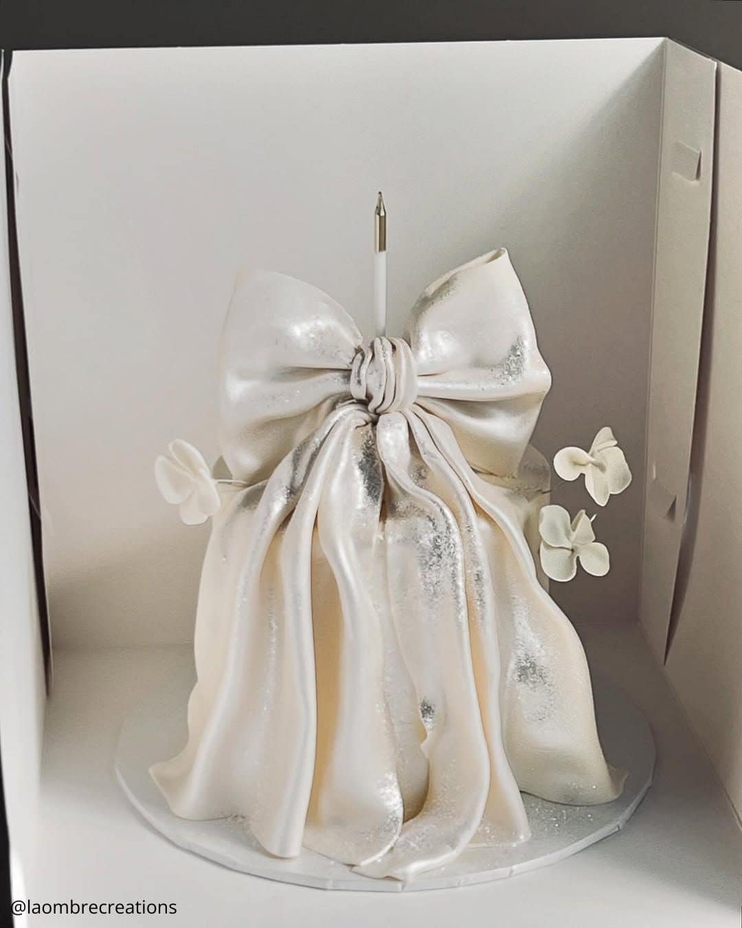 unique wedding cakes modern white cake wrapped in dramatic oversized edible bow laombrecreations
