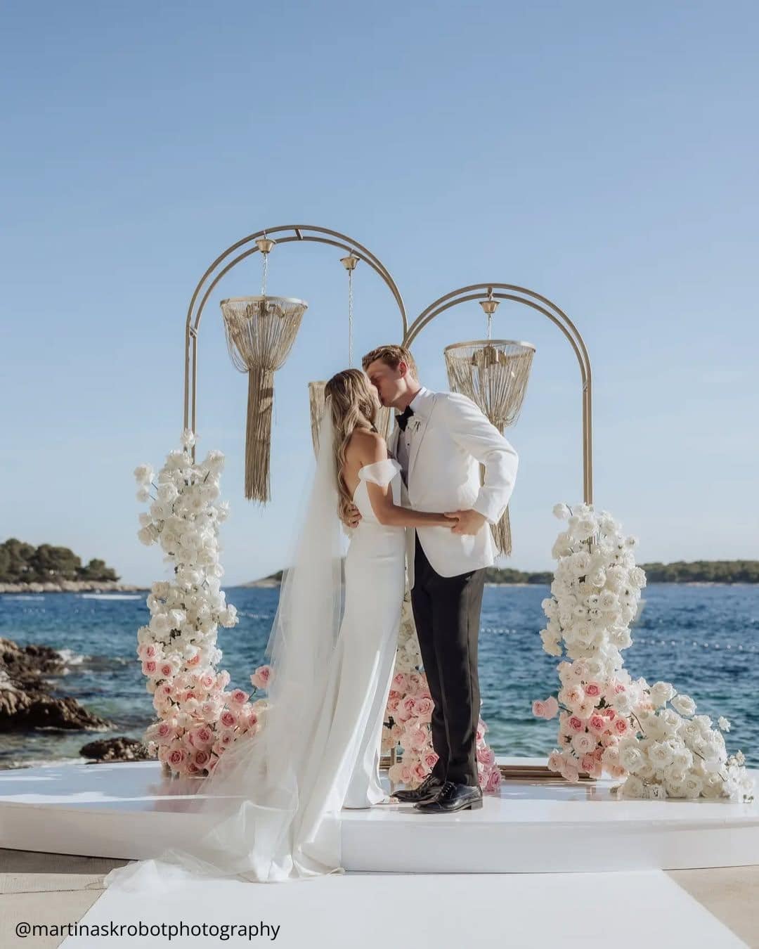 wedding photos happy brides at the ceremony kissing against the sea background martinaskrobotphotography
